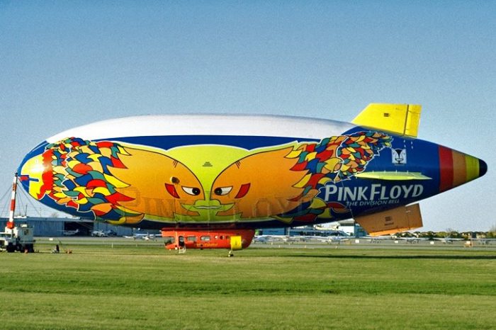 A colorful airship sitting on top of an airport runway.